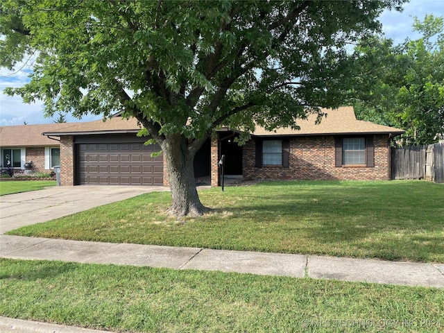 single story home featuring a front lawn and a garage