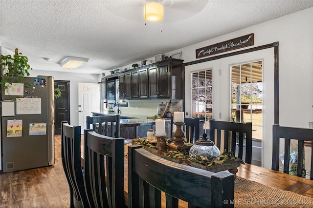 dining space featuring light hardwood / wood-style floors, ceiling fan, and a textured ceiling