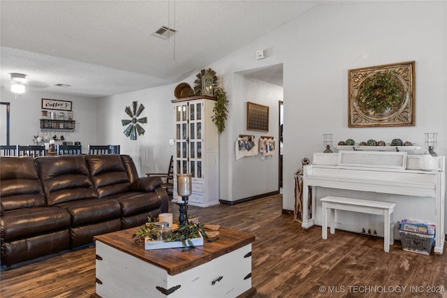 living room with lofted ceiling, a textured ceiling, and dark hardwood / wood-style floors