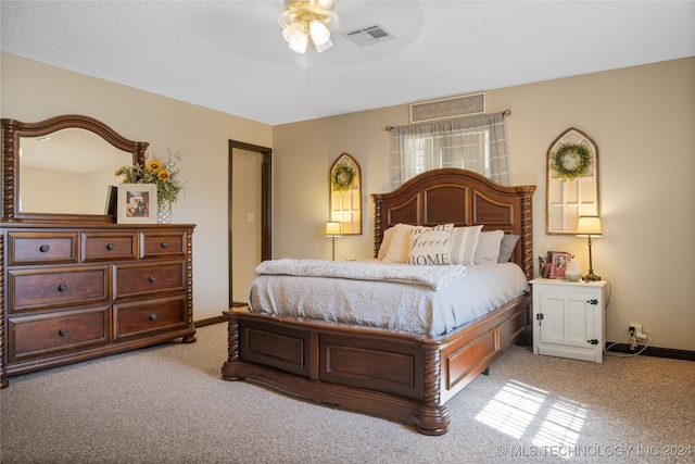 carpeted bedroom featuring ceiling fan and a textured ceiling