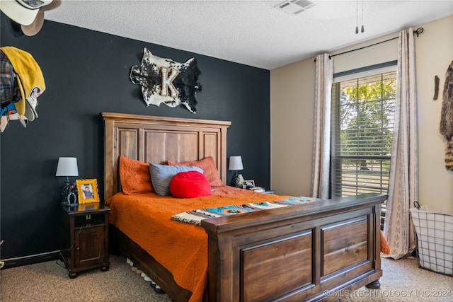 bedroom featuring a textured ceiling and light carpet