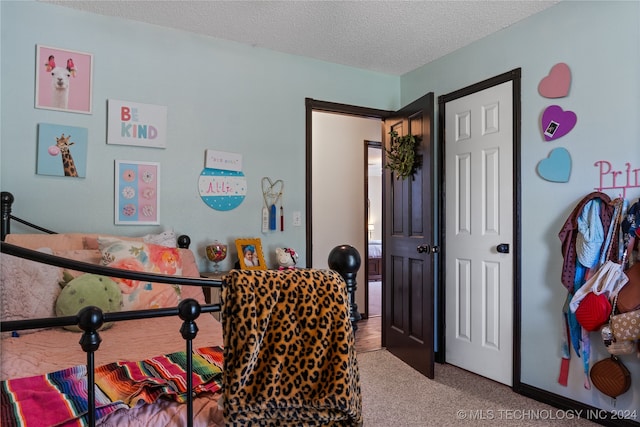 bedroom featuring a textured ceiling and carpet