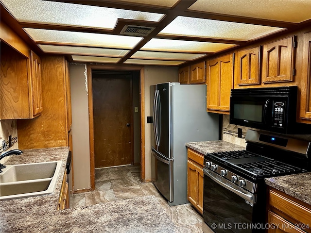 kitchen featuring stainless steel appliances, a textured ceiling, and sink