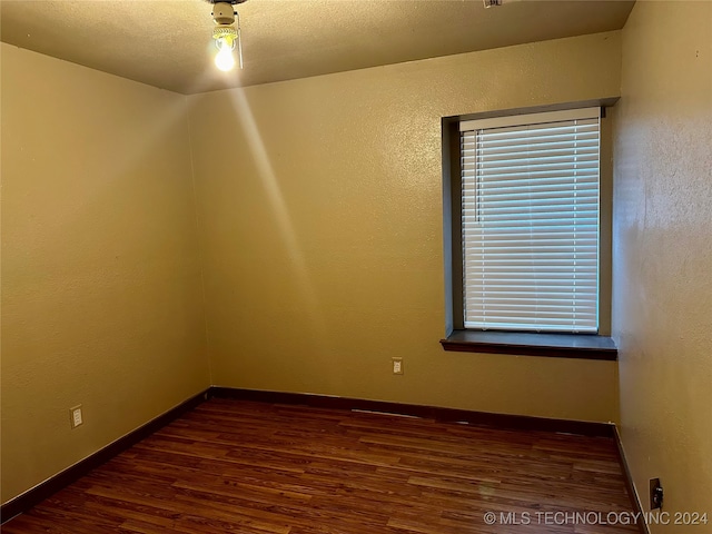 spare room with dark wood-type flooring