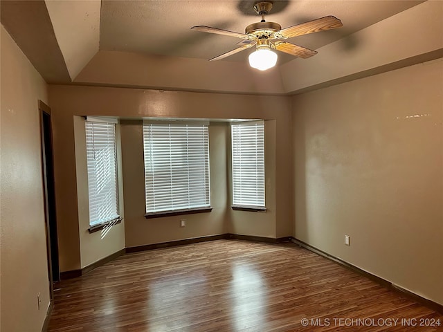 spare room featuring hardwood / wood-style floors, vaulted ceiling, and ceiling fan