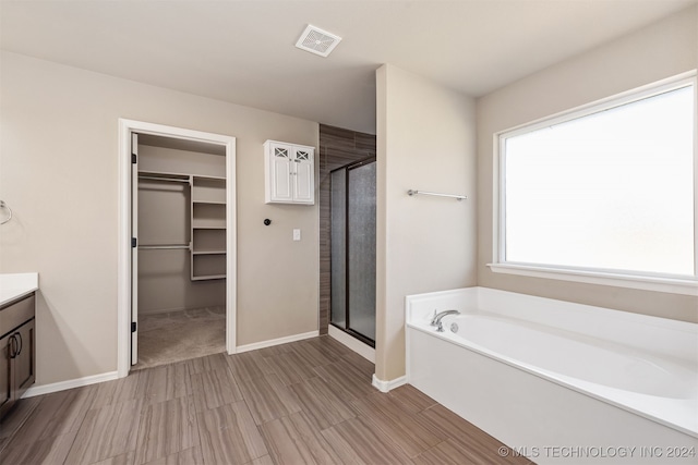 bathroom with vanity and shower with separate bathtub