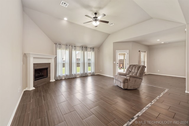 unfurnished room featuring ceiling fan, lofted ceiling, dark hardwood / wood-style floors, and a tile fireplace