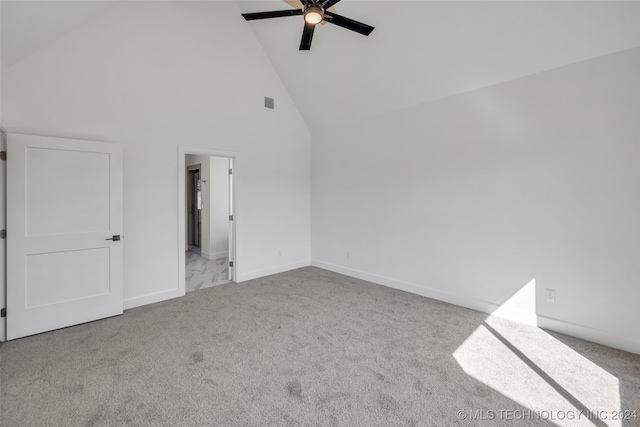 carpeted spare room with high vaulted ceiling and ceiling fan