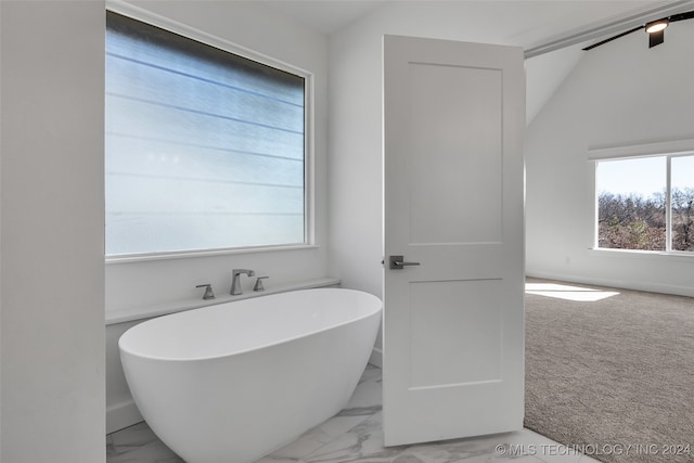 bathroom featuring a bathing tub and lofted ceiling