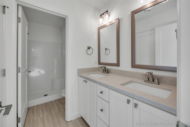 bathroom featuring a shower, vanity, and toilet