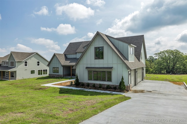 modern inspired farmhouse with a front yard and a garage