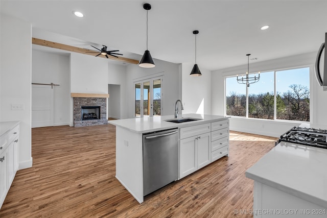 kitchen with a center island with sink, appliances with stainless steel finishes, sink, and a healthy amount of sunlight