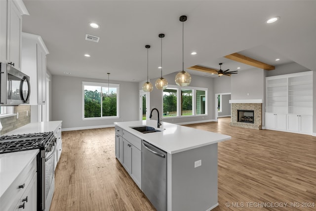 kitchen featuring plenty of natural light, sink, an island with sink, white cabinetry, and appliances with stainless steel finishes