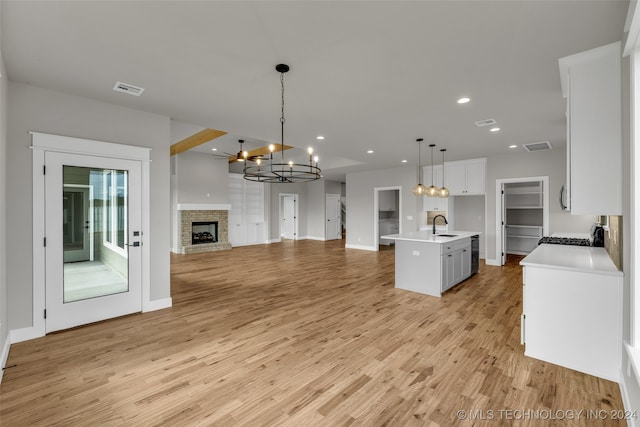 kitchen featuring pendant lighting, a kitchen island with sink, sink, and light hardwood / wood-style flooring