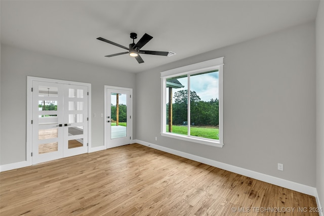 unfurnished room with light wood-type flooring, ceiling fan, and french doors