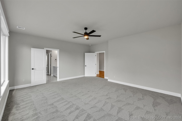 unfurnished bedroom featuring ceiling fan, carpet floors, and connected bathroom