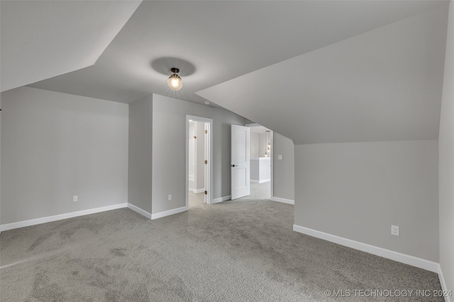 additional living space featuring carpet and lofted ceiling