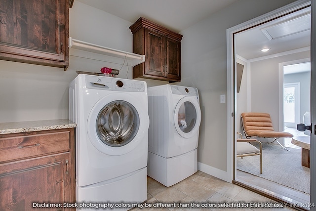 washroom with ornamental molding, washing machine and dryer, light tile patterned flooring, and cabinets