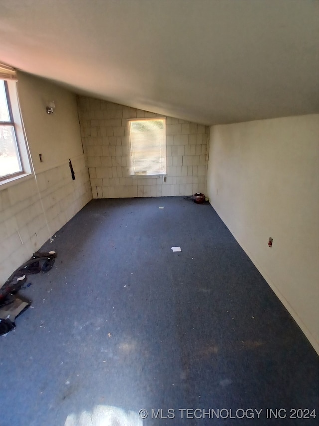 unfurnished room featuring lofted ceiling