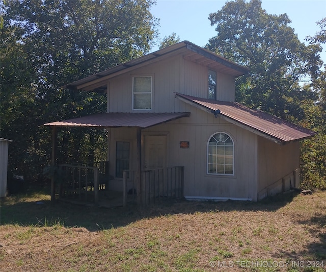 back of house featuring a lawn