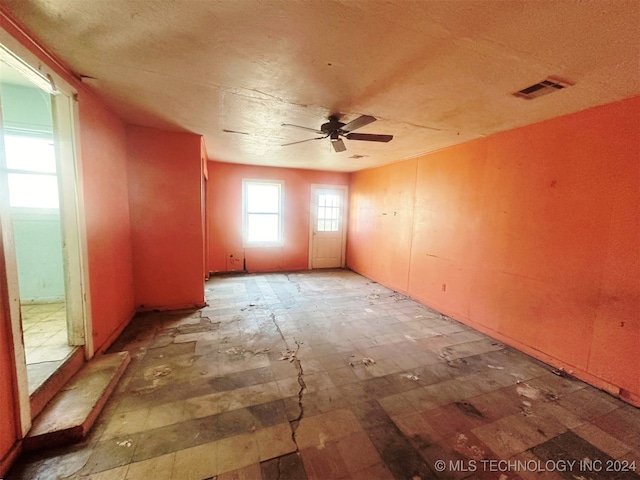 spare room featuring a textured ceiling and ceiling fan