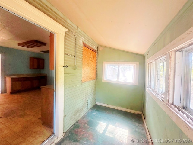 unfurnished sunroom featuring vaulted ceiling