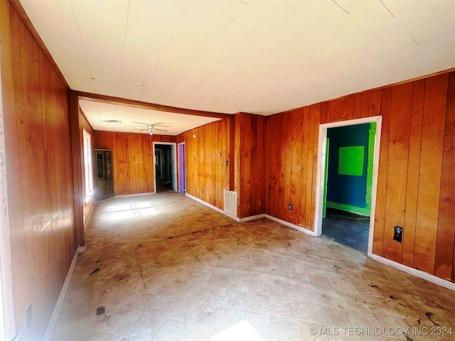 unfurnished room with wood walls and ceiling fan