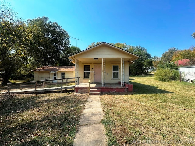 bungalow-style house featuring a front lawn and covered porch