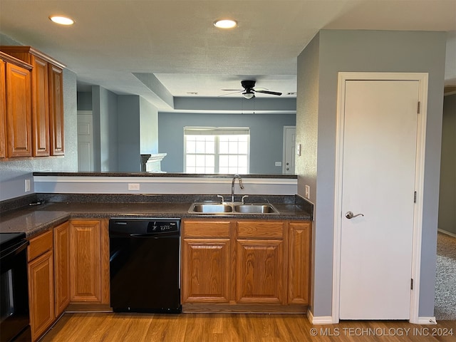 kitchen with light hardwood / wood-style floors, black appliances, sink, and ceiling fan