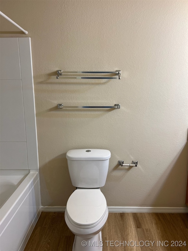 bathroom featuring shower / bath combination, hardwood / wood-style flooring, and toilet