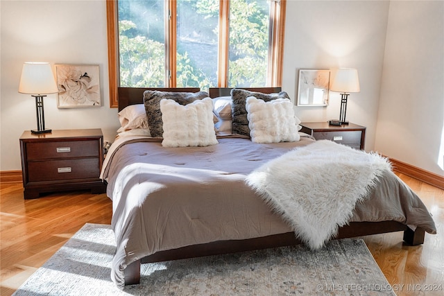 bedroom with baseboards and wood finished floors