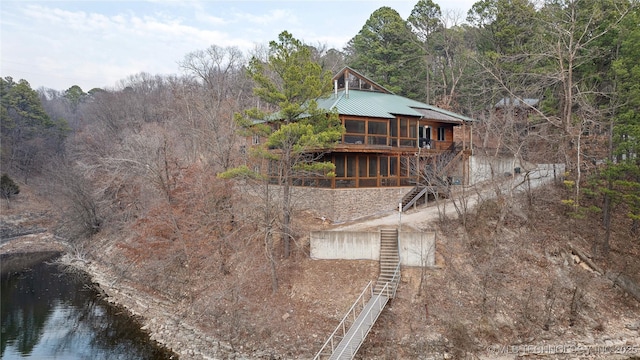 back of property featuring a water view and a wooded view