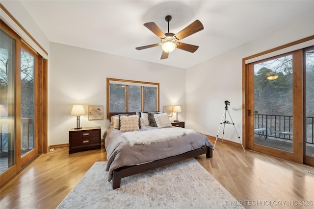 bedroom with access to outside, multiple windows, and light wood-style flooring