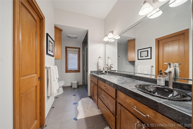 bathroom with a sink, double vanity, tile patterned flooring, and toilet