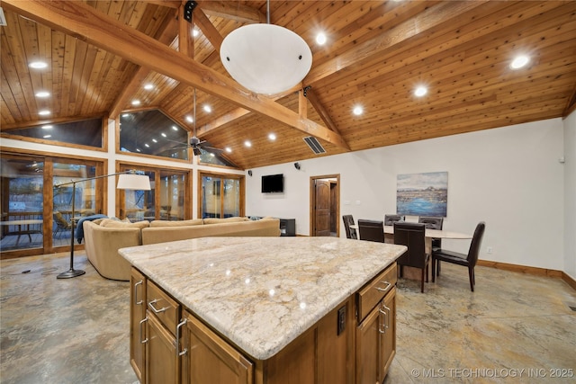 kitchen with a center island, beam ceiling, brown cabinets, wood ceiling, and light stone countertops