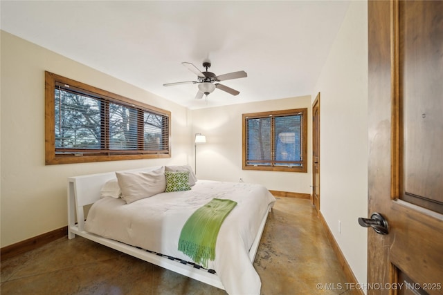 bedroom with concrete flooring, a ceiling fan, and baseboards