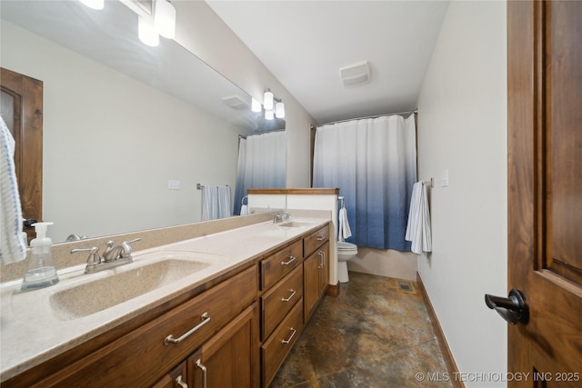 full bathroom with baseboards, a sink, toilet, and double vanity