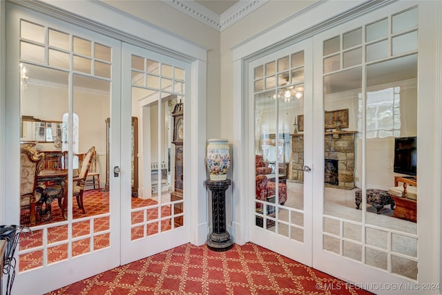 entryway featuring a fireplace, french doors, and crown molding