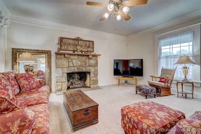 carpeted living room with ceiling fan, a stone fireplace, and ornamental molding