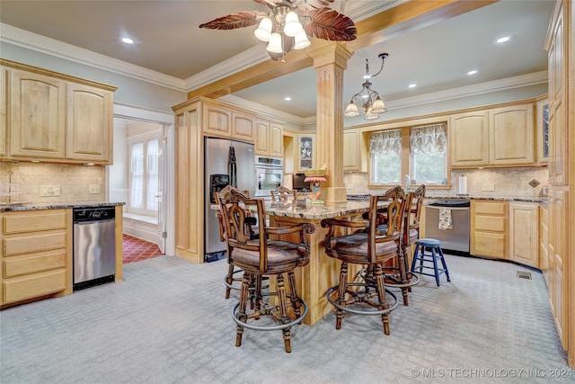 kitchen featuring appliances with stainless steel finishes, light brown cabinetry, light stone counters, and light colored carpet