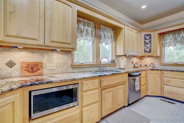 kitchen featuring plenty of natural light, ornamental molding, light brown cabinets, and appliances with stainless steel finishes