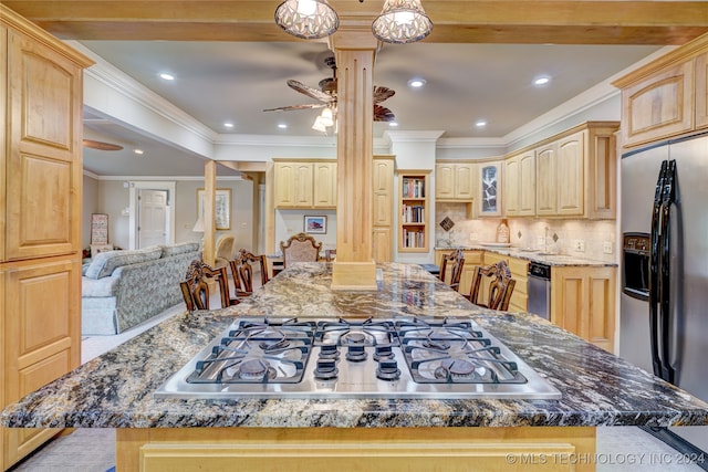 kitchen featuring appliances with stainless steel finishes, light brown cabinetry, and ornate columns