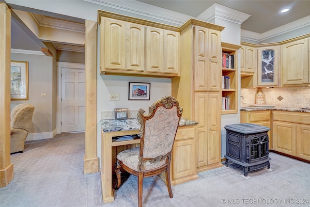 kitchen with a wood stove, light carpet, ornamental molding, and light brown cabinets