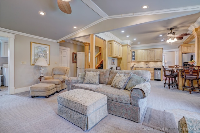 carpeted living room featuring lofted ceiling, ornamental molding, washer / clothes dryer, and ceiling fan