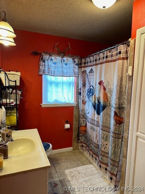 bathroom featuring vanity, tile patterned flooring, a textured ceiling, and curtained shower