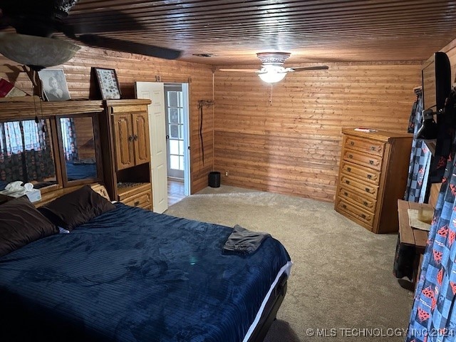 bedroom with wooden walls, ceiling fan, carpet floors, and wood ceiling