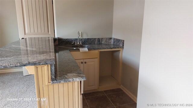 kitchen with dark tile patterned floors and sink