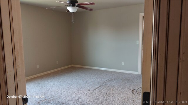 unfurnished room with ceiling fan and carpet flooring