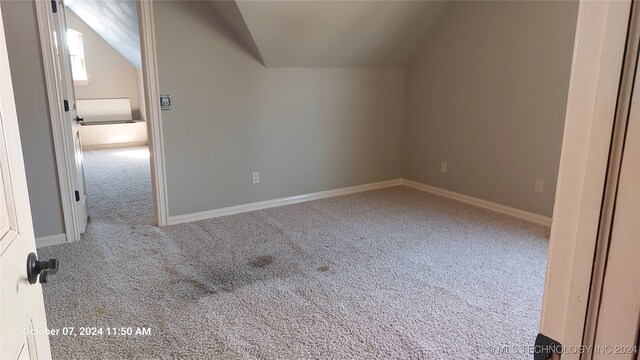 bonus room with carpet floors and vaulted ceiling