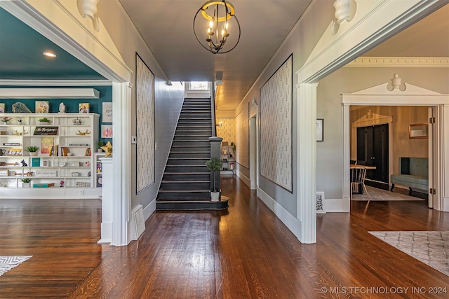 stairway featuring hardwood / wood-style flooring and an inviting chandelier